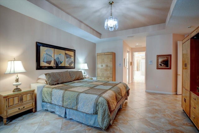 bedroom featuring a notable chandelier and a raised ceiling