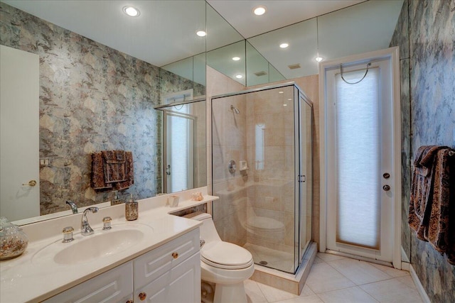 bathroom featuring tile patterned floors, toilet, vanity, and an enclosed shower