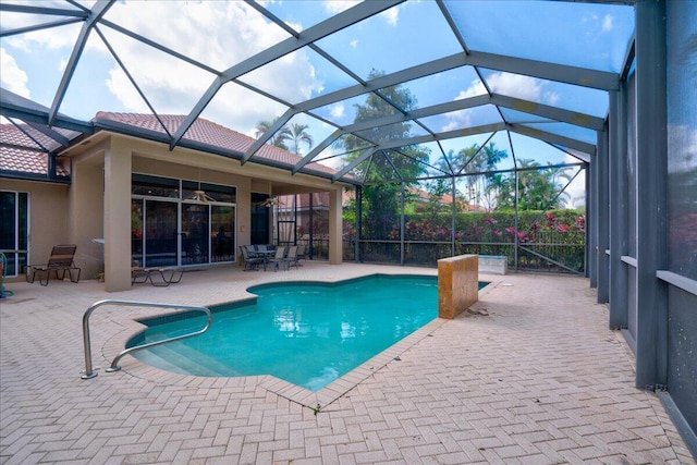 view of pool featuring glass enclosure and a patio area