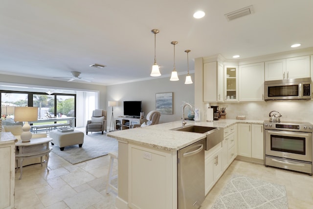 kitchen with stainless steel appliances, ceiling fan, pendant lighting, and kitchen peninsula