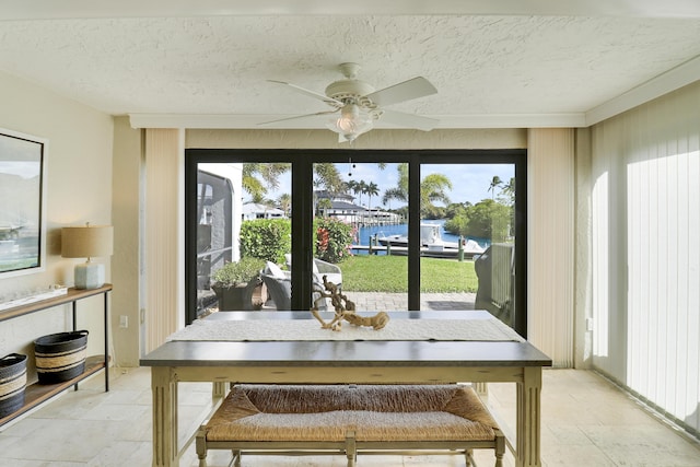 dining room featuring a textured ceiling, ceiling fan, and crown molding