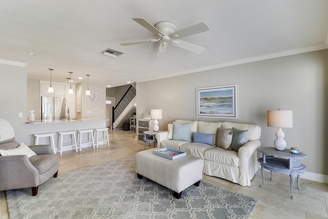 tiled living room with ceiling fan and crown molding