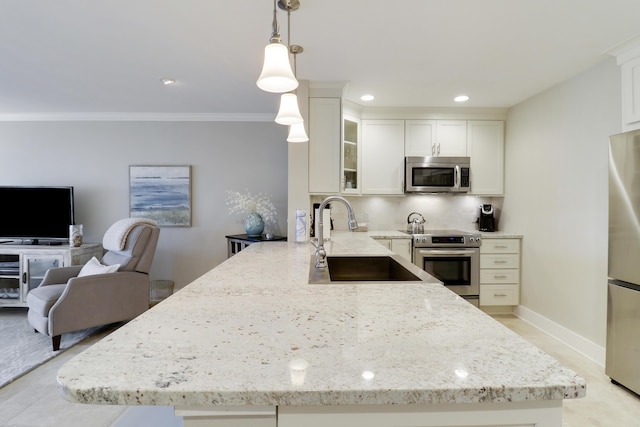 kitchen with appliances with stainless steel finishes, hanging light fixtures, kitchen peninsula, white cabinets, and sink