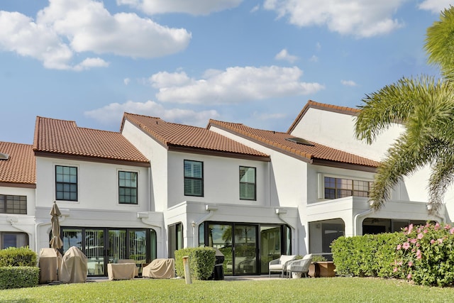 rear view of property featuring a lawn