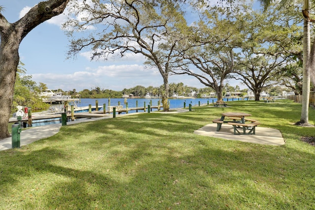 dock area with a lawn and a water view