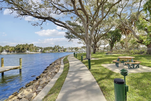 surrounding community featuring a lawn and a water view