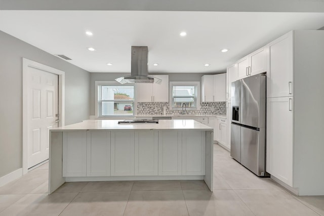 kitchen featuring a center island, sink, stainless steel fridge with ice dispenser, white cabinets, and island range hood