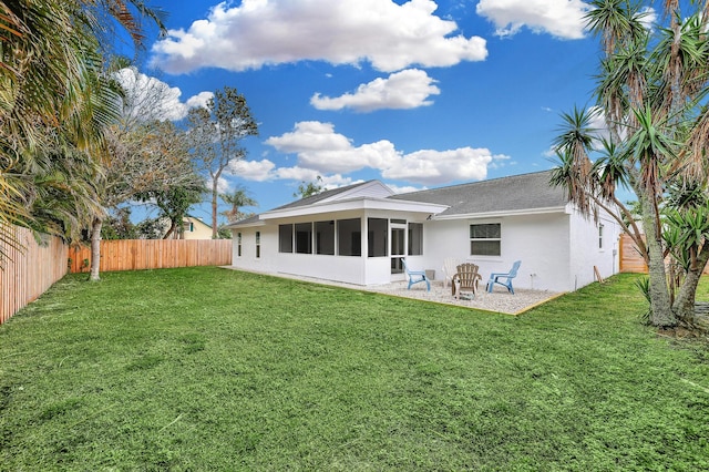 back of property with a sunroom and a yard