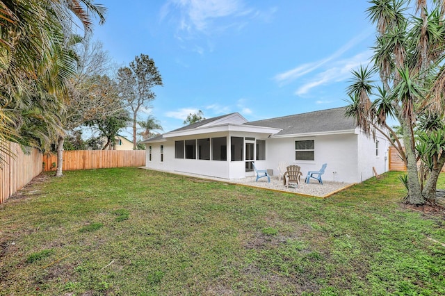 rear view of property featuring a patio area, a yard, and a sunroom