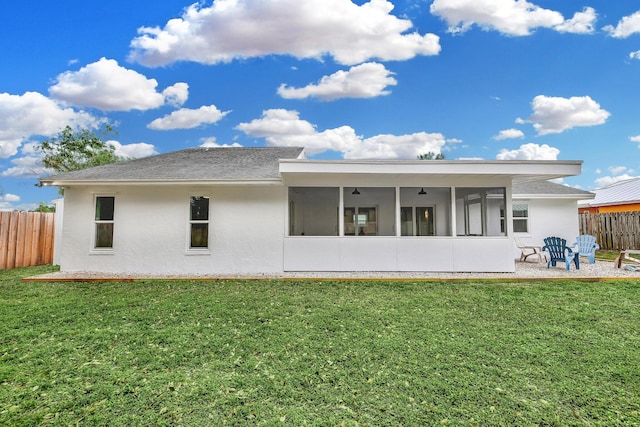 back of house featuring a sunroom and a lawn