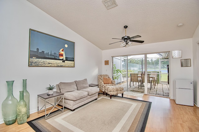 living room featuring ceiling fan, wood-type flooring, and a textured ceiling