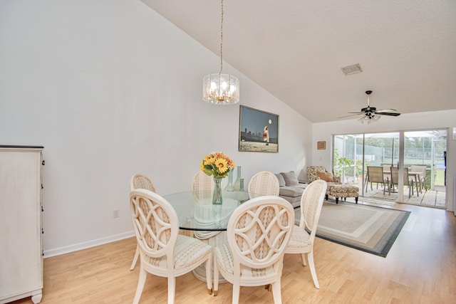 dining area featuring light hardwood / wood-style floors, ceiling fan with notable chandelier, and lofted ceiling