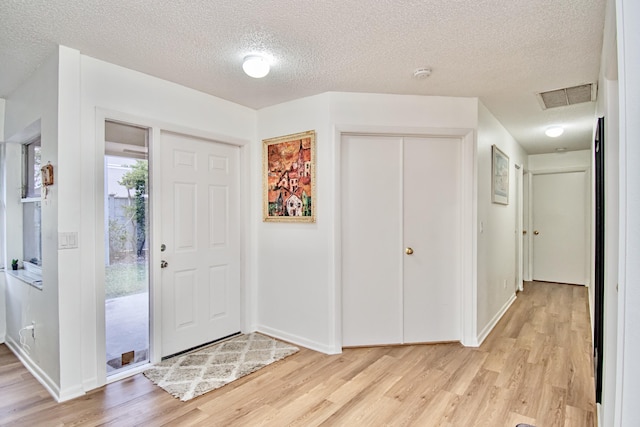 entrance foyer featuring light hardwood / wood-style floors and a textured ceiling