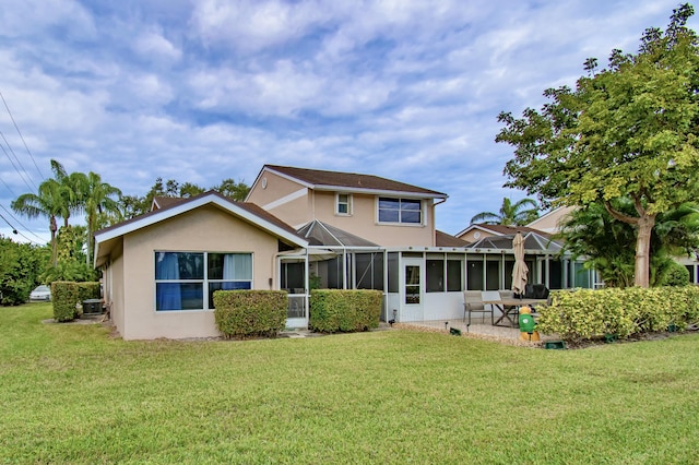 back of house featuring a patio, glass enclosure, and a yard