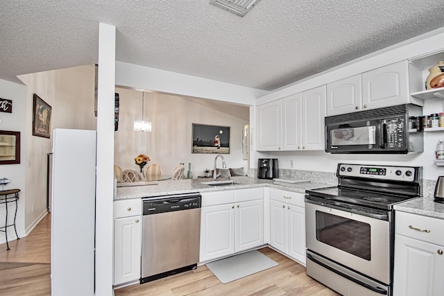 kitchen with a textured ceiling, white cabinetry, stainless steel appliances, light hardwood / wood-style floors, and sink