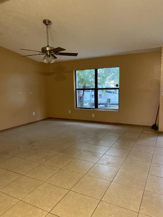 spare room with ceiling fan and light tile patterned floors