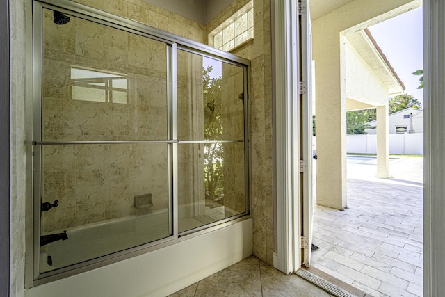 bathroom featuring combined bath / shower with glass door and tile patterned floors