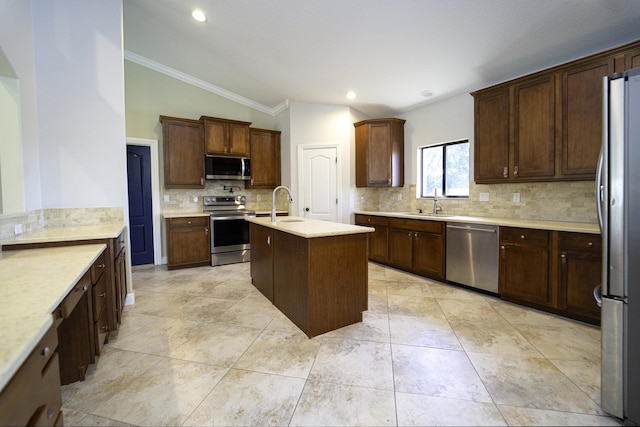 kitchen with stainless steel appliances, tasteful backsplash, lofted ceiling, a kitchen island with sink, and dark brown cabinetry