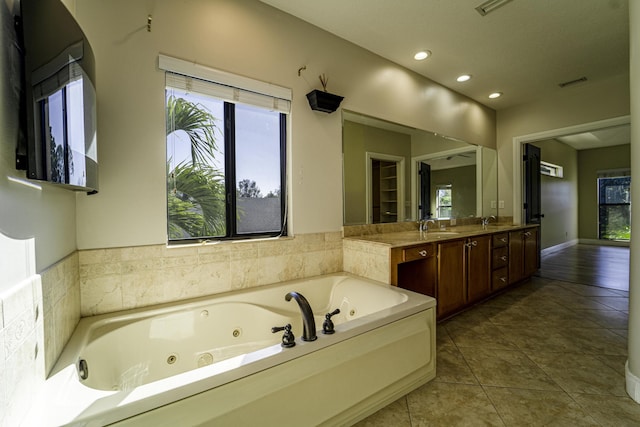 bathroom featuring a washtub, tile patterned flooring, and vanity