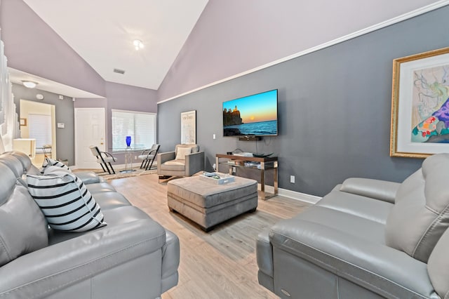 living room featuring high vaulted ceiling, light wood-type flooring, and baseboards