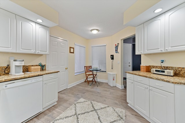 kitchen with light stone counters, baseboards, white cabinets, light wood-type flooring, and dishwasher