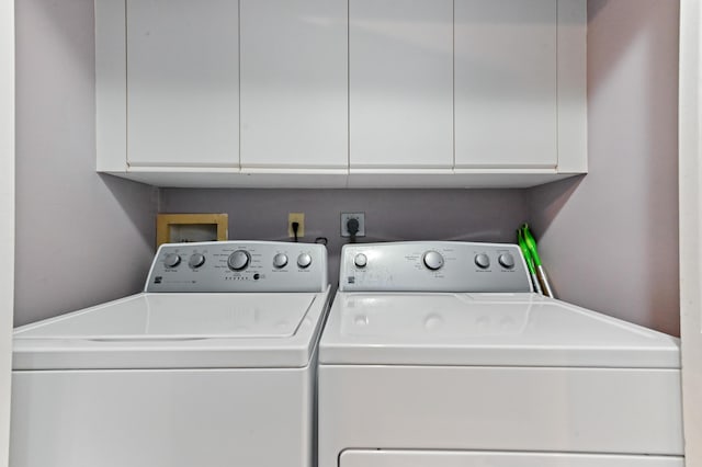 laundry area with washing machine and clothes dryer and cabinet space