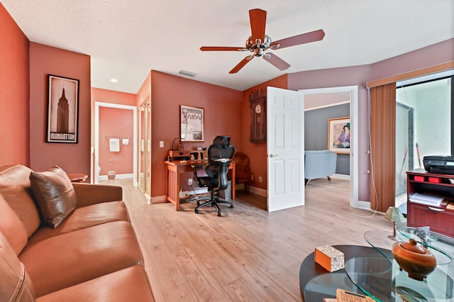 home office featuring light wood-style floors, visible vents, baseboards, and a ceiling fan