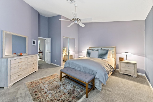 carpeted bedroom with ensuite bathroom, high vaulted ceiling, a ceiling fan, visible vents, and baseboards