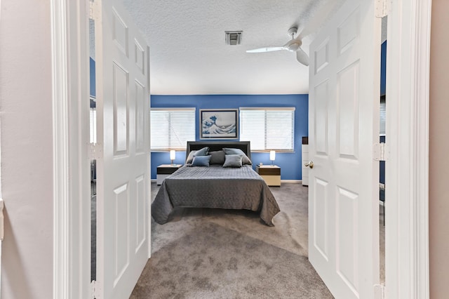 bedroom with carpet, baseboards, ceiling fan, and a textured ceiling