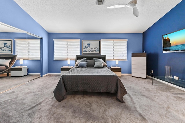 carpeted bedroom featuring ceiling fan, a textured ceiling, visible vents, and baseboards