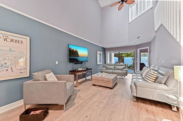 living room with light wood-style floors, visible vents, and baseboards