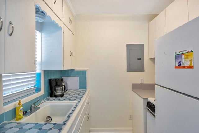 kitchen featuring sink, white appliances, white cabinetry, plenty of natural light, and electric panel