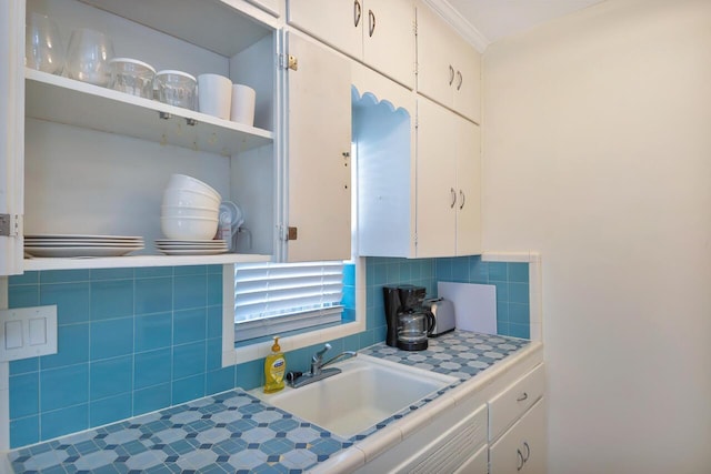 kitchen featuring white cabinetry, tile counters, and sink