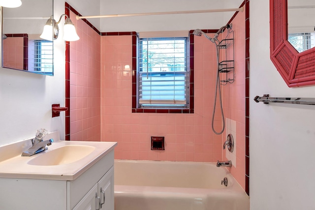 bathroom with tiled shower / bath combo and vanity