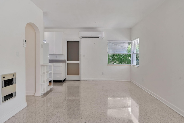 unfurnished living room with heating unit and a wall unit AC