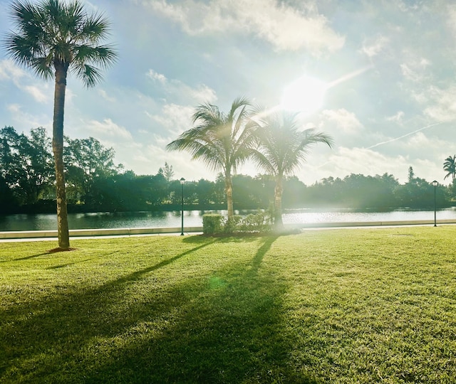 surrounding community featuring a water view and a lawn