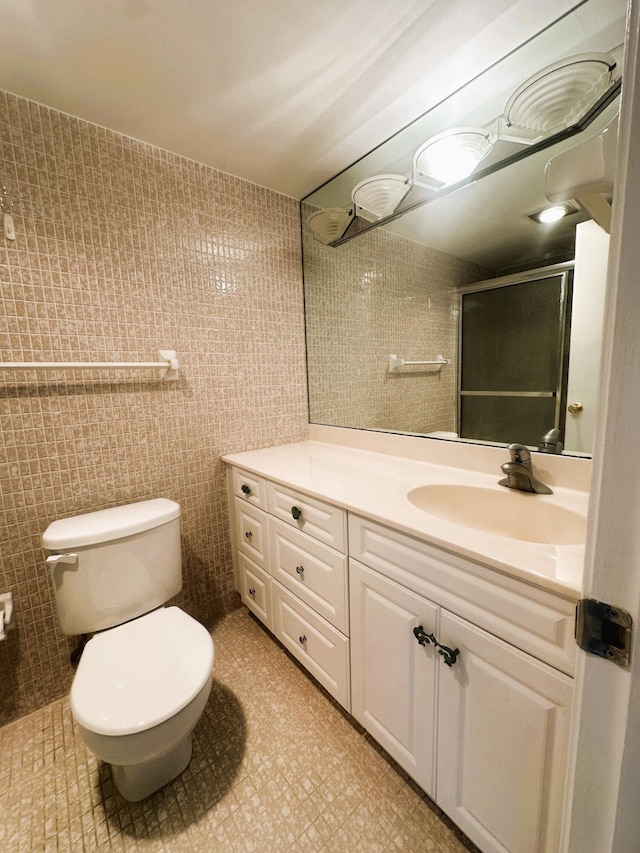 bathroom with vanity, a shower stall, and toilet