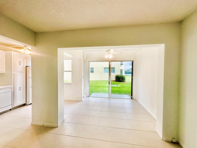 interior space with light tile patterned flooring, a ceiling fan, and a textured ceiling