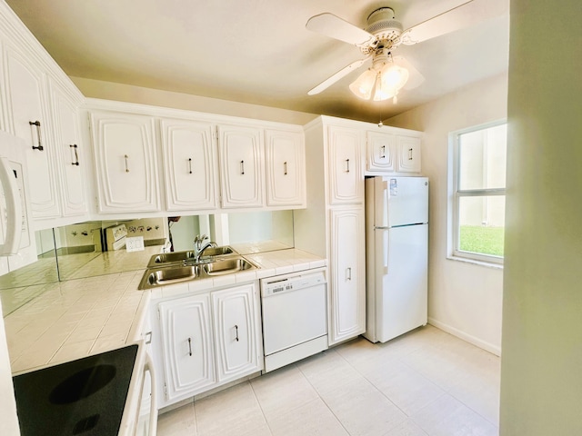 kitchen featuring tile countertops, white appliances, white cabinets, and a sink