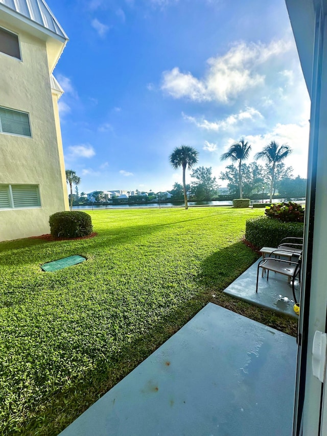 view of yard featuring a patio area and a water view