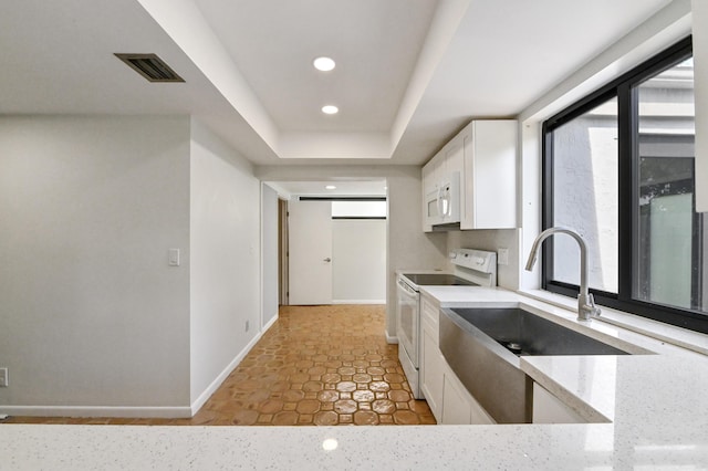 kitchen with white cabinetry, sink, white appliances, and light stone countertops