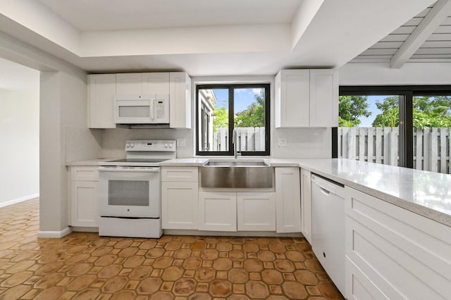 kitchen with white cabinets, backsplash, sink, and white appliances