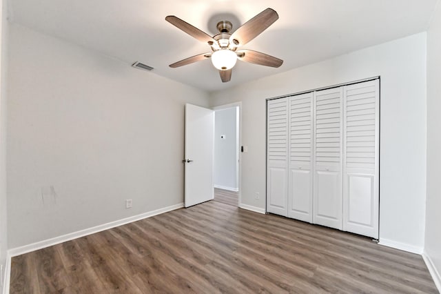 unfurnished bedroom featuring ceiling fan, a closet, and dark hardwood / wood-style flooring