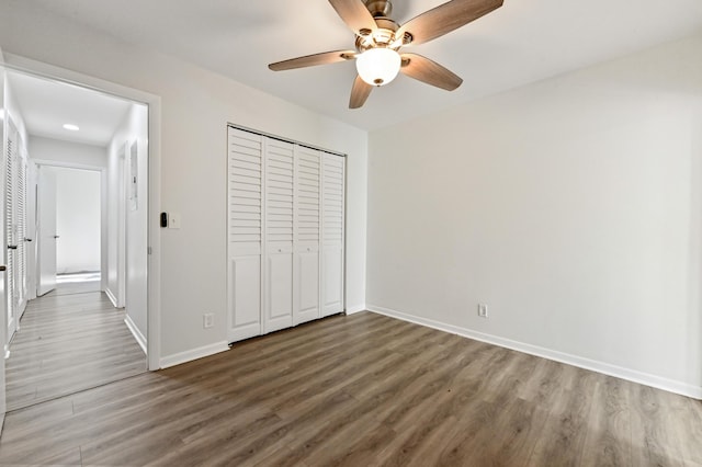 unfurnished bedroom featuring ceiling fan, dark hardwood / wood-style flooring, and a closet