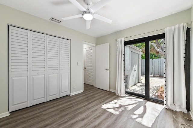 unfurnished bedroom with ceiling fan, access to exterior, a closet, and dark hardwood / wood-style flooring