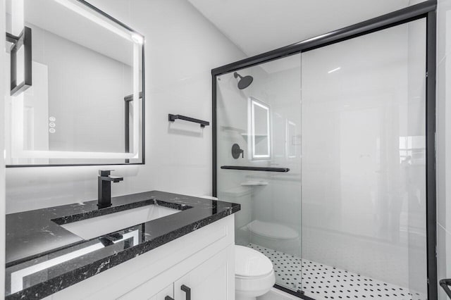 bathroom with toilet, a shower with shower door, and vanity