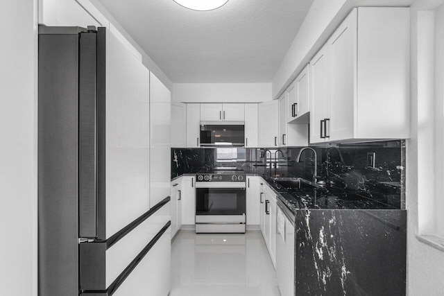 kitchen with sink, electric range, white cabinets, and refrigerator