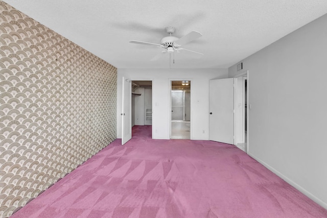 unfurnished bedroom with connected bathroom, carpet flooring, ceiling fan, a textured ceiling, and a closet