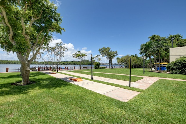 view of home's community featuring a water view and a lawn