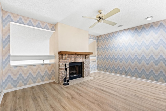 unfurnished living room with ceiling fan, a textured ceiling, and hardwood / wood-style flooring